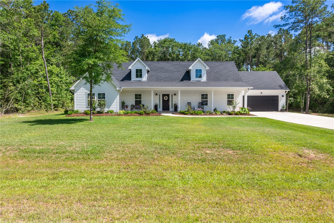 8729 Nathan Drive Waller, TX 77484 - Photo 4 of 48 View of front of home with a garage, driveway, a porch, and a front lawn