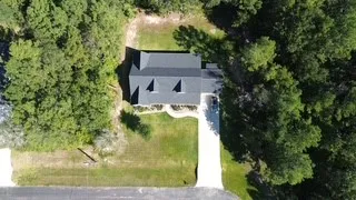 an aerial view of residential houses with outdoor space and trees