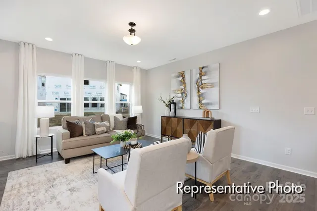 a living room with furniture and a view of kitchen