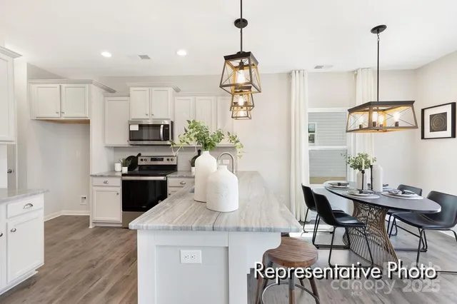 a kitchen with a table chairs refrigerator and microwave