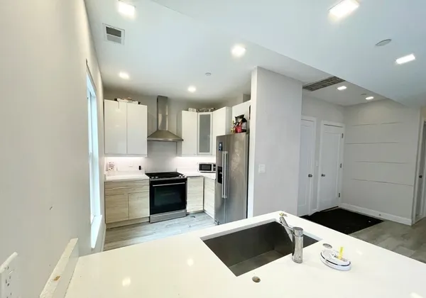 a kitchen with a refrigerator and a stove top oven