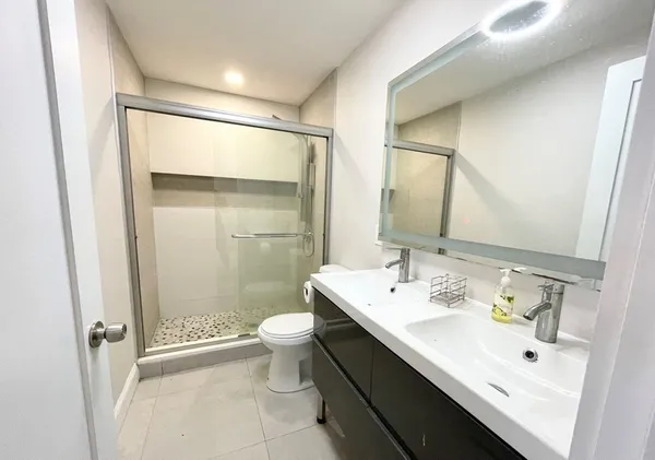 a bathroom with a sink and mirror with toilet
