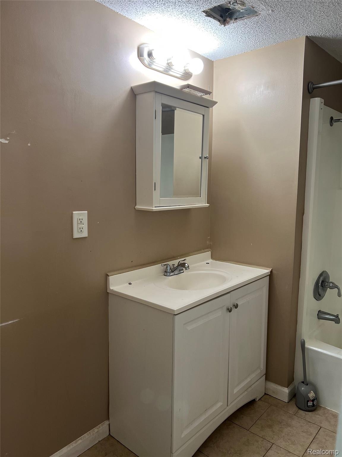 35945 Herman Street Romulus, MI 48174 - Photo 21 of 26 Full bath featuring shower / bath combination, vanity, light tile patterned flooring, and a textured ceiling
