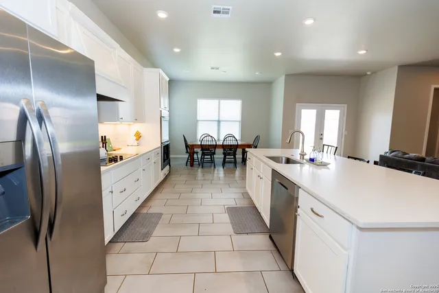a large kitchen with kitchen island a sink counter space and stainless steel appliances
