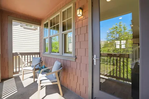a view of a balcony and dining area with wooden floor