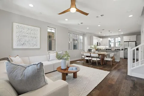 a living room with furniture and a dining table with kitchen view