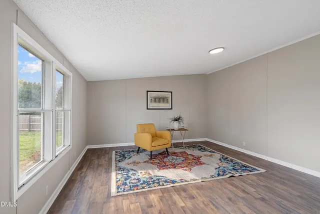 a living room with wooden floor and a window