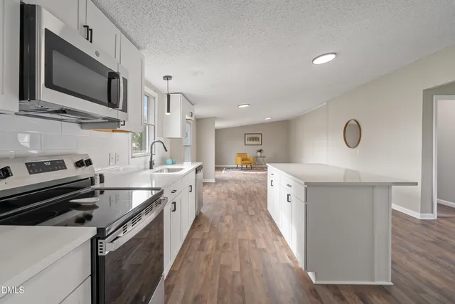 a kitchen with a sink stove top oven and microwave