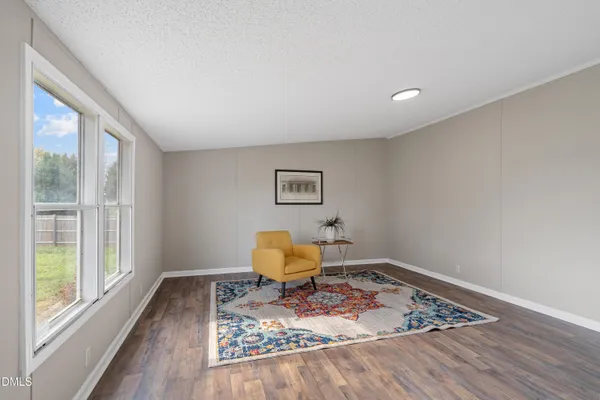 a living room with wooden floor and a window
