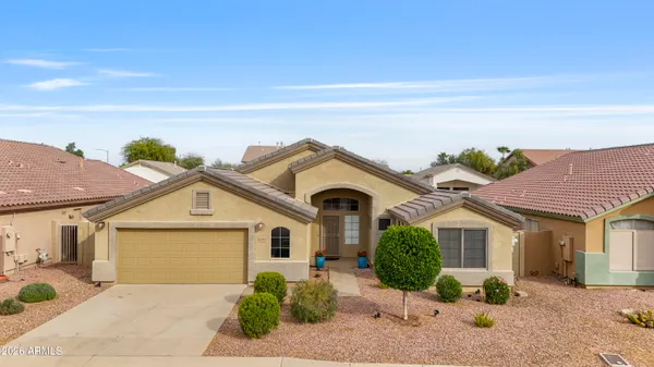 a front view of a house with a yard and potted plants