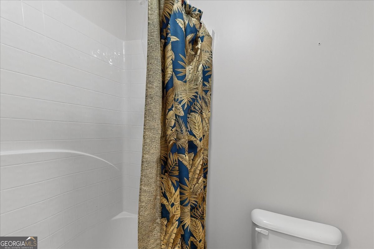 518 River Overlook Forsyth, GA 31029 - Photo 47 of 85 a bathroom with a toilet and a shower curtain