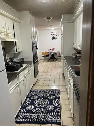 a kitchen with a sink a stove and cabinets