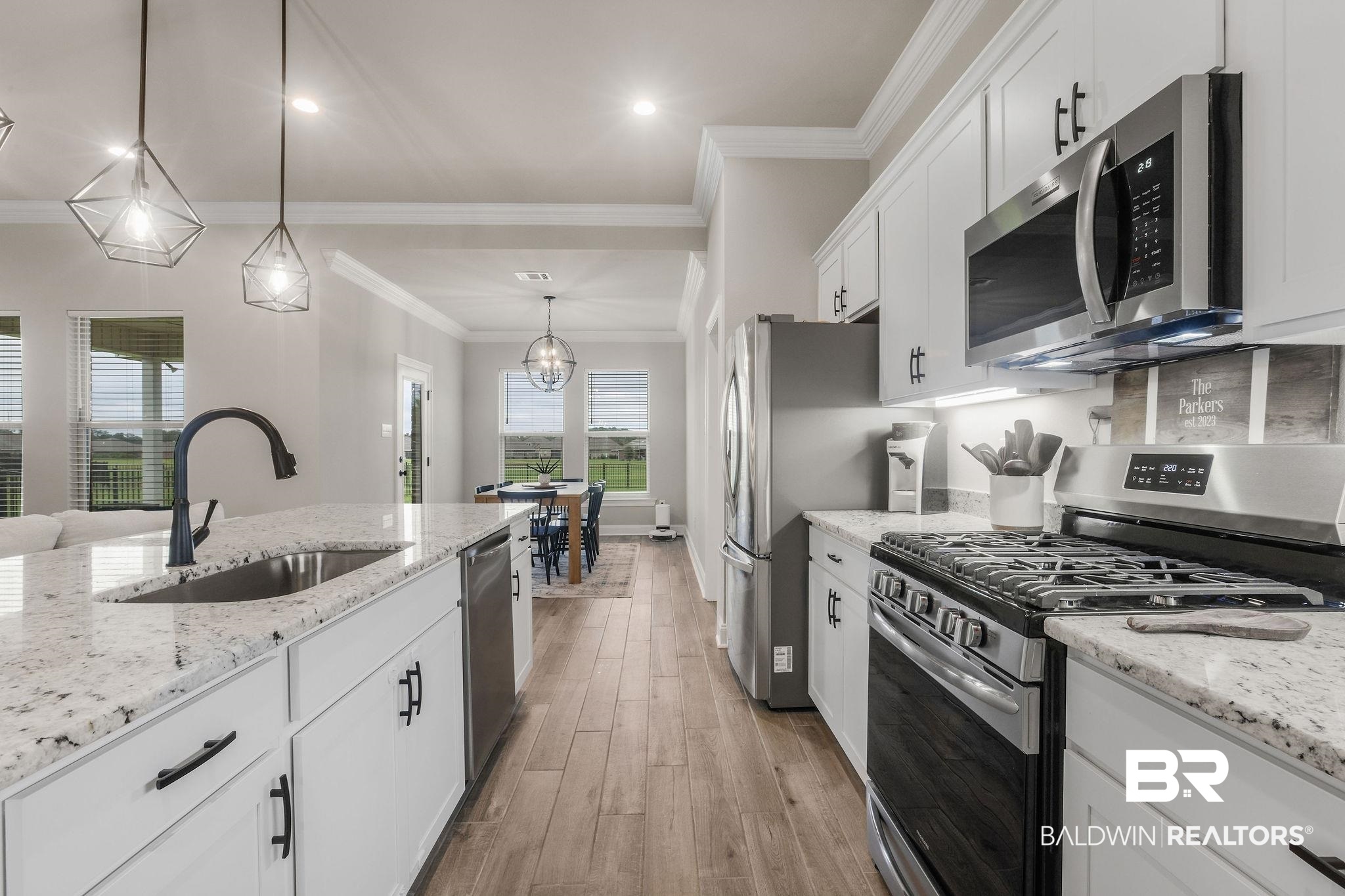 9988 Chipper Lane Foley, AL 36535 - Photo 12 of 26 Kitchen with appliances with stainless steel finishes, sink, decorative light fixtures, light hardwood / wood-style flooring, and white cabinets