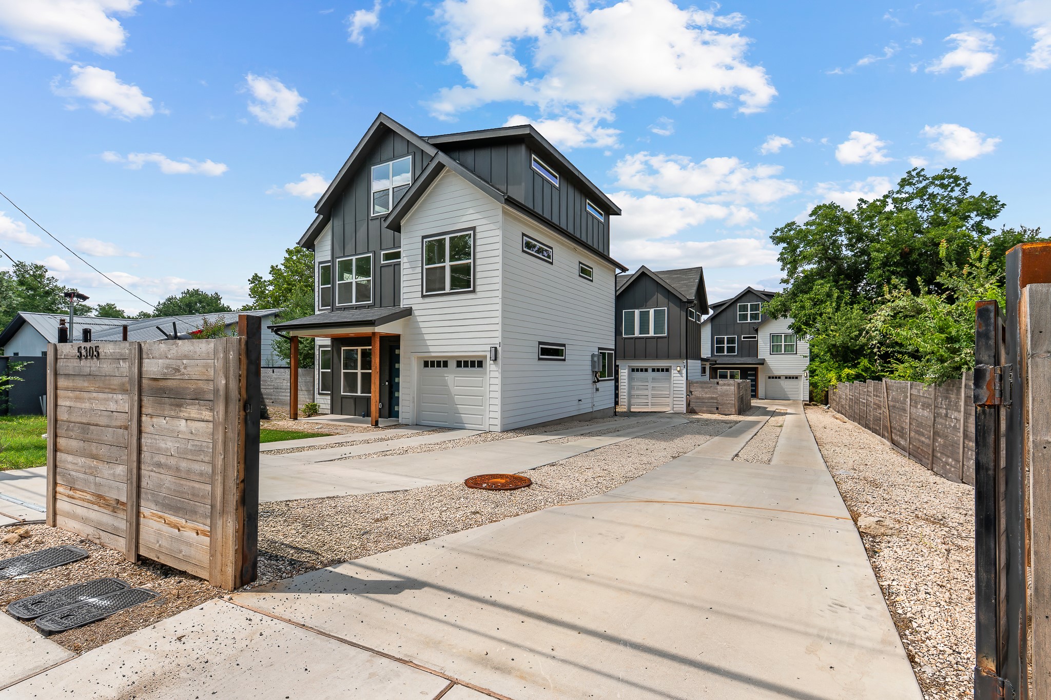 5305 Ledesma Road, Unit 4 Austin, TX 78721 - Photo 36 of 40 Modern townhomes line a concrete and gravel driveway, offering private garage access and contemporary curb appeal.