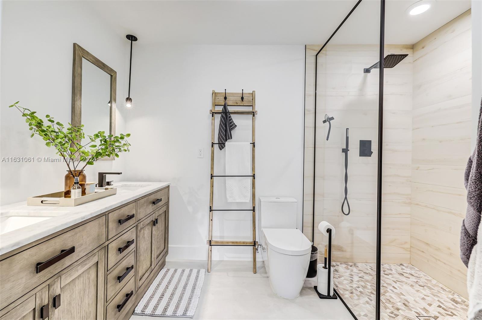 10900 Southwest 128th Street Miami, FL 33186 - Photo 20 of 34 a spacious bathroom with a double vanity sink a toilet a mirror and shower