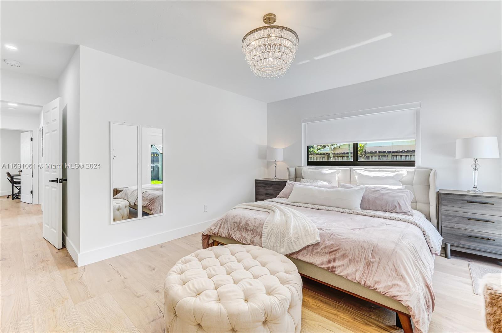 10900 Southwest 128th Street Miami, FL 33186 - Photo 22 of 34 a bedroom with a large bed and a chandelier