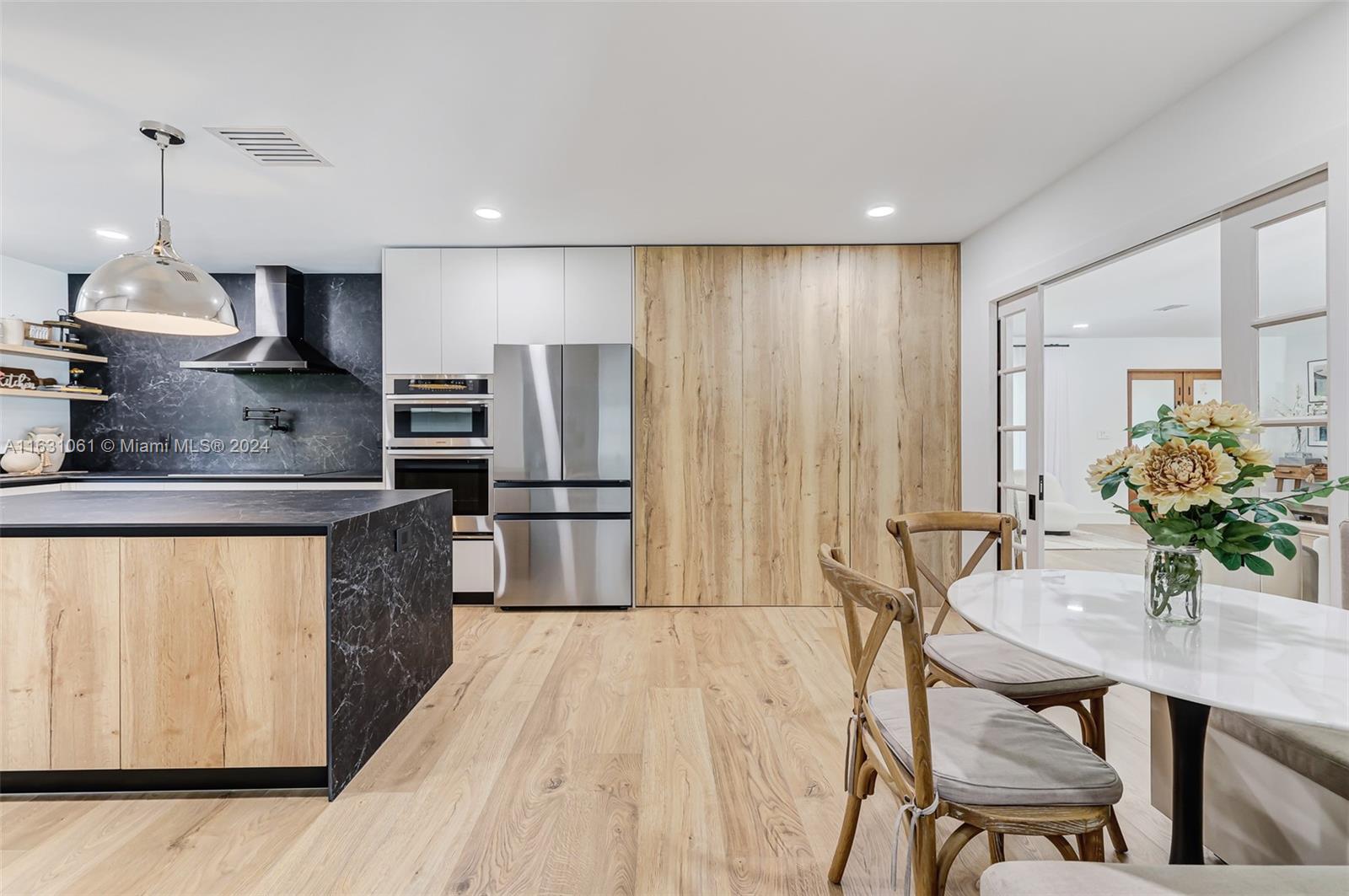 10900 Southwest 128th Street Miami, FL 33186 - Photo 26 of 34 a kitchen with stainless steel appliances a dining table chairs refrigerator and sink