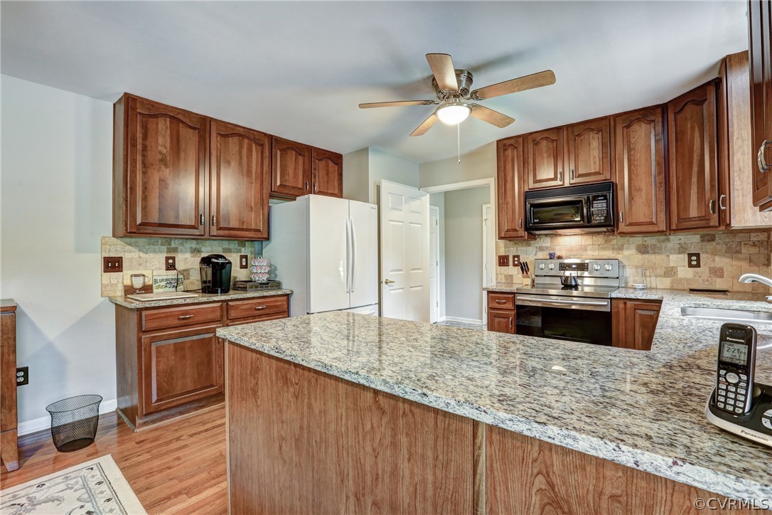 2511 Fairground Road Maidens, VA 23102 - Photo 11 of 29 a kitchen with granite countertop wooden cabinets a stove a sink and a oven