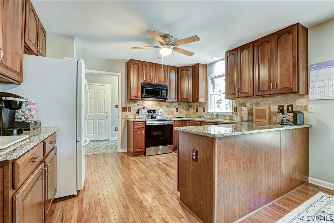 2511 Fairground Road Maidens, VA 23102 - Photo 10 of 29 a kitchen with stainless steel appliances granite countertop a stove top oven a sink dishwasher a refrigerator and a dining table with wooden floor
