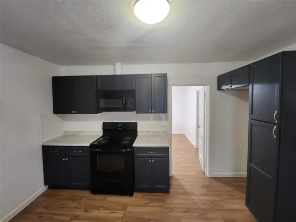 a kitchen with granite countertop a refrigerator stove and microwave
