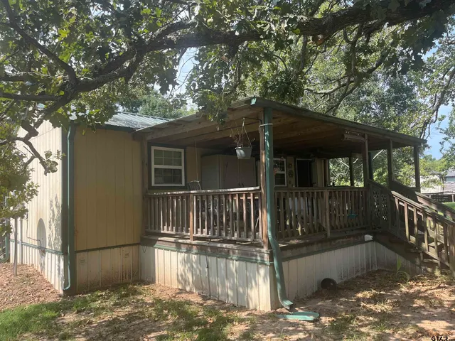 a view of a house with a yard balcony and wooden fence