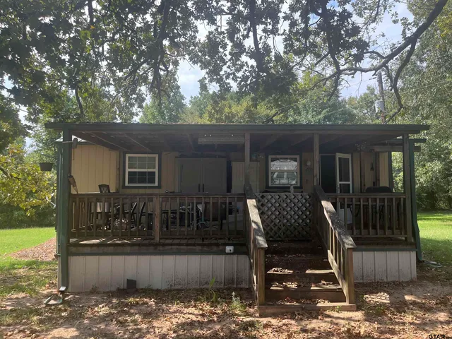 a view of house with backyard outdoor seating and hardwood