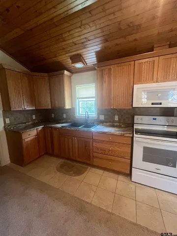 a kitchen with granite countertop a stove cabinets and a sink