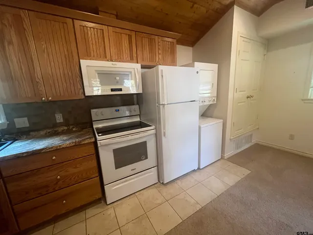 a kitchen with a refrigerator sink and cabinets
