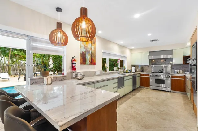 a kitchen with stainless steel appliances granite countertop a sink a stove and a refrigerator