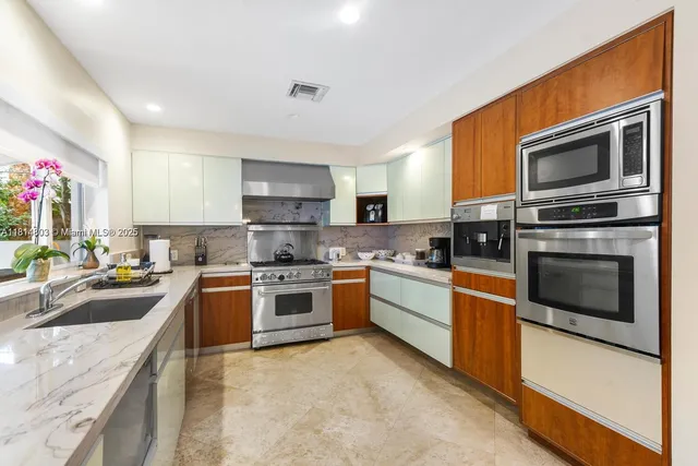a kitchen with granite countertop a stove top oven sink and cabinets