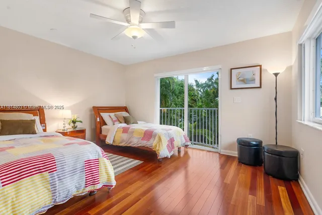 a bedroom with two beds and wooden floor