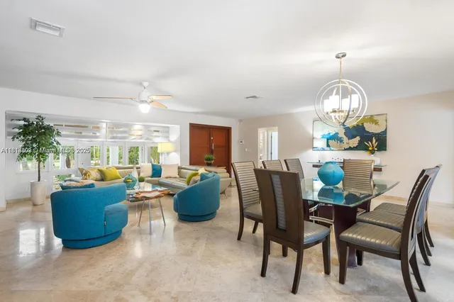 a view of a dining room with furniture a chandelier and a large window