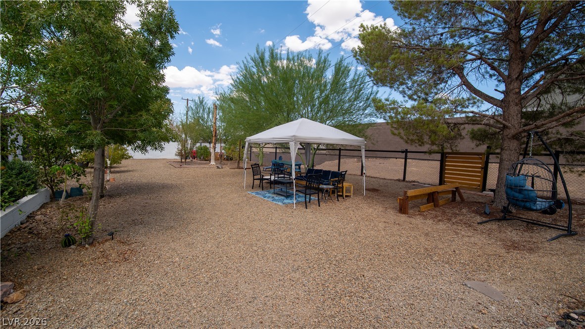 425 Blackridge Road Henderson, NV 89015 - Photo 4 of 31 Mature trees shade a spacious gravel yard bordered by secure perimeter fencing.