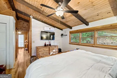 a bedroom with a large bed and a flat tv screen on dresser