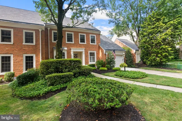 a front view of a house with a yard and trees