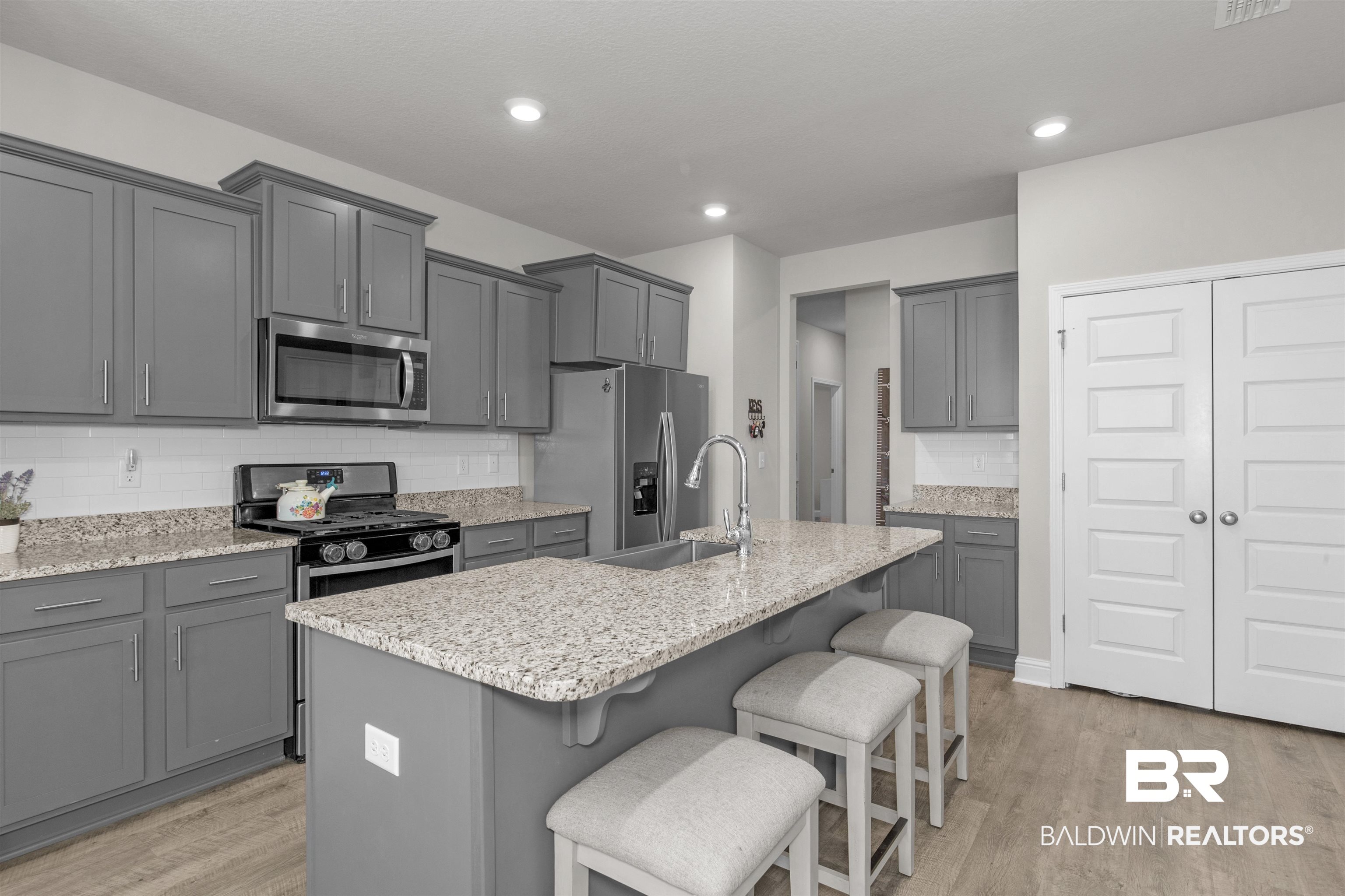 2345 Laurel Street Semmes, AL 36575 - Photo 10 of 31 Kitchen featuring stainless steel appliances, light wood-style flooring, a breakfast bar area, tasteful backsplash, and recessed lighting