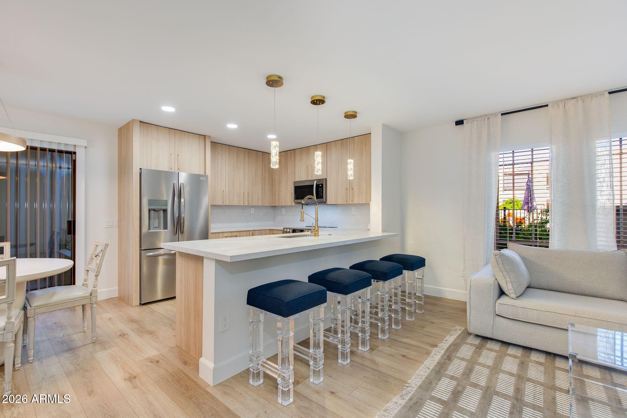 5201 North 24th Street, Unit 107 Phoenix, AZ 85016 - Photo 4 of 15 a view of kitchen with kitchen island stainless steel appliances refrigerator stove dining table and chairs