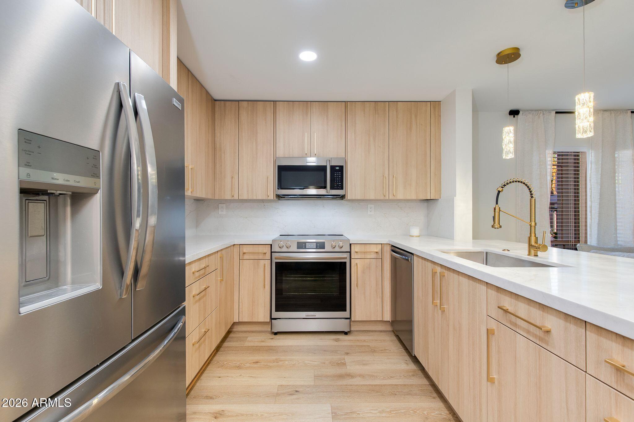 5201 North 24th Street, Unit 107 Phoenix, AZ 85016 - Photo 6 of 15 a kitchen with stainless steel appliances granite countertop a sink and a stove