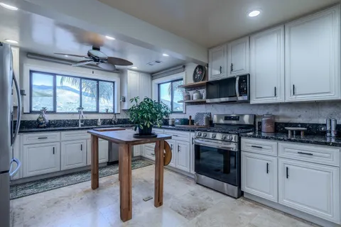a kitchen with stainless steel appliances kitchen island granite countertop a sink and cabinets