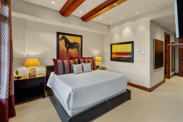 a bedroom with a bed and a lamp on dresser