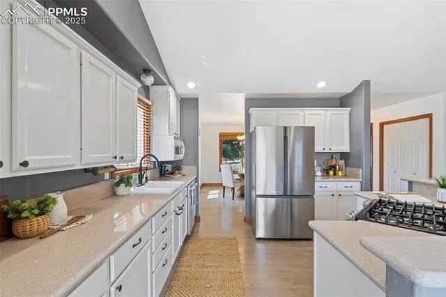a kitchen with stainless steel appliances a refrigerator sink and cabinets