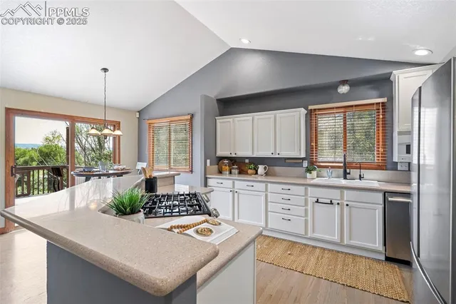 a kitchen with a stove a sink a dining table and chairs