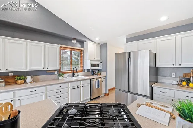 a kitchen with stainless steel appliances a refrigerator sink and cabinets