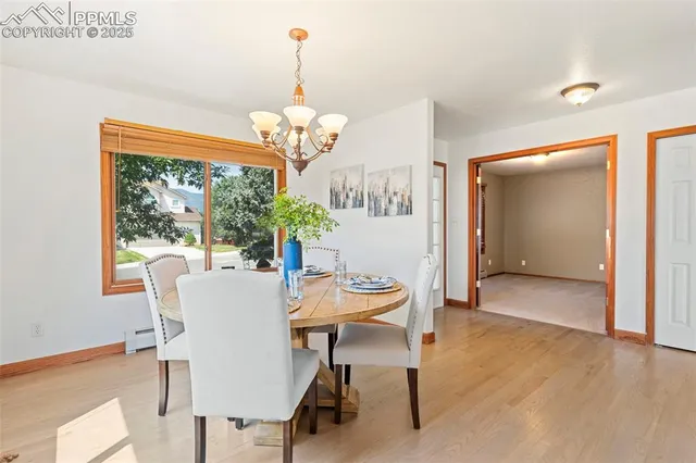 a view of a dining room with furniture a chandelier and wooden floor