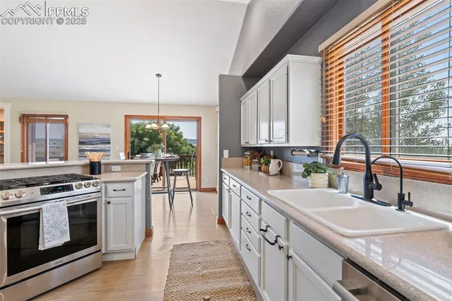 a kitchen with stainless steel appliances granite countertop a sink stove and cabinets