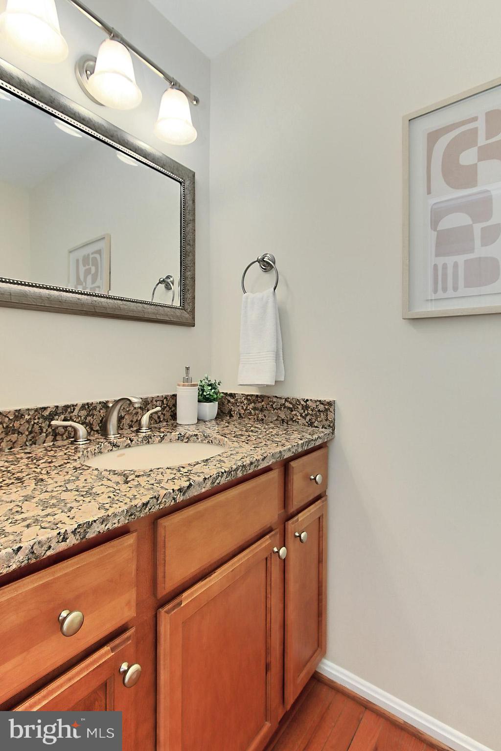10704 Cross School Road Reston, VA 20191 - Photo 18 of 56 a bathroom with a granite countertop sink and a mirror