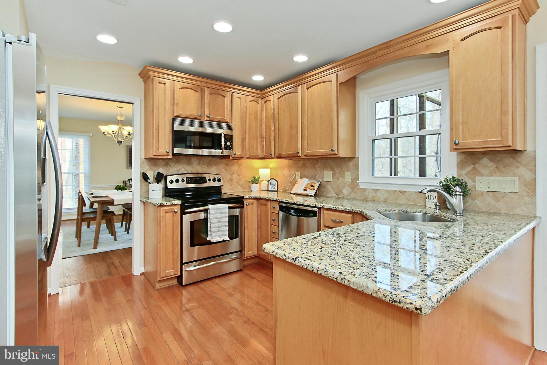 10704 Cross School Road Reston, VA 20191 - Photo 3 of 56 a kitchen with stainless steel appliances granite countertop a stove a sink and a microwave