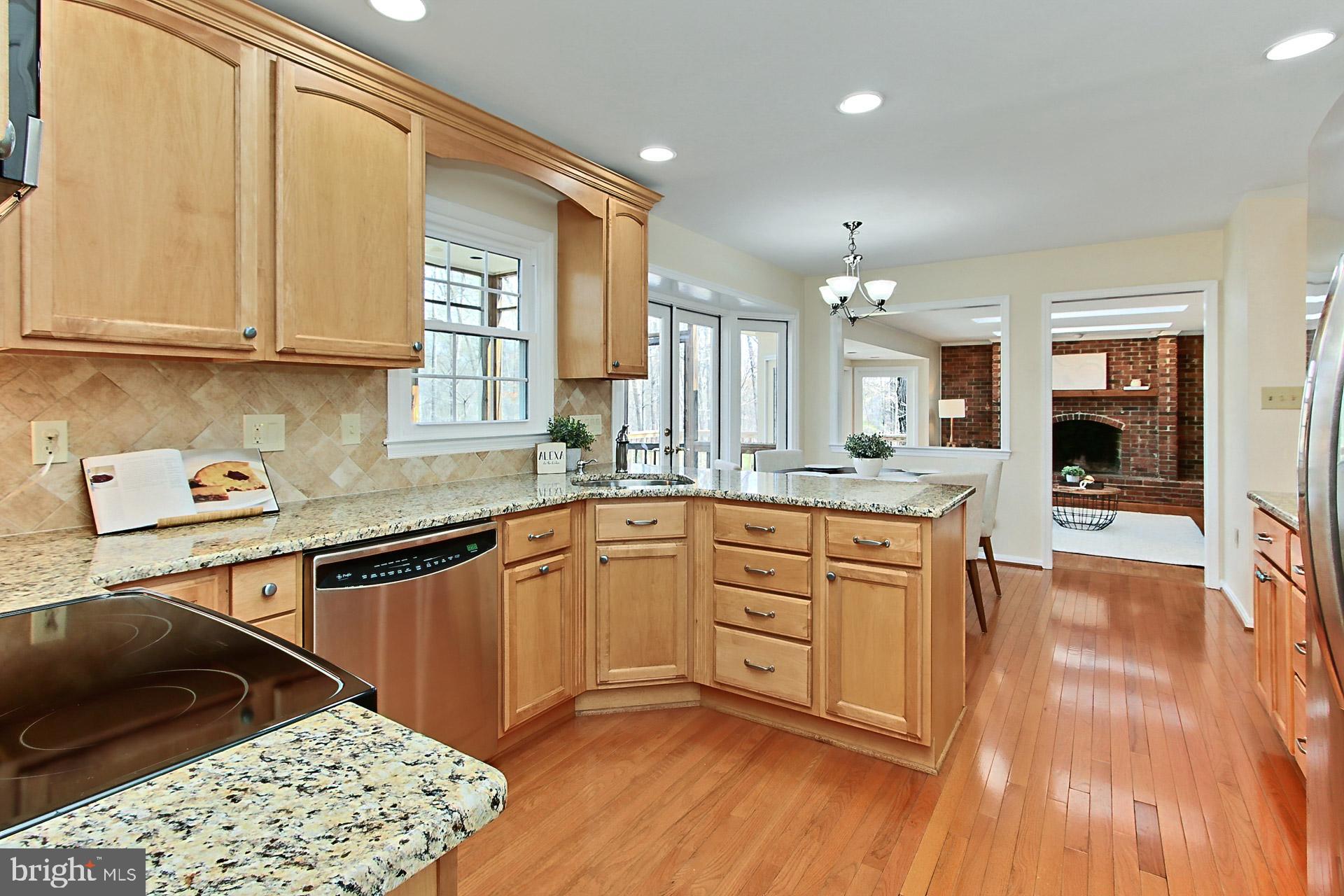 10704 Cross School Road Reston, VA 20191 - Photo 4 of 56 a kitchen with stainless steel appliances granite countertop a sink dishwasher a stove and white cabinets with wooden floor