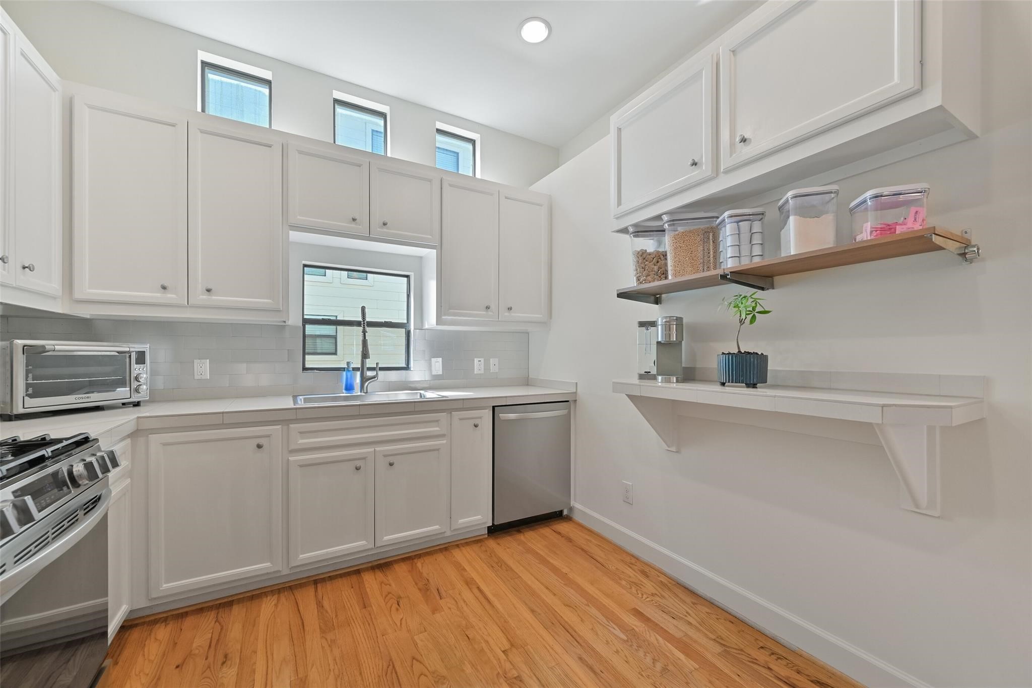 8715 Meadowcroft Drive, Unit 1002 Houston, TX 77063 - Photo 11 of 24 a kitchen with cabinets a sink and appliances