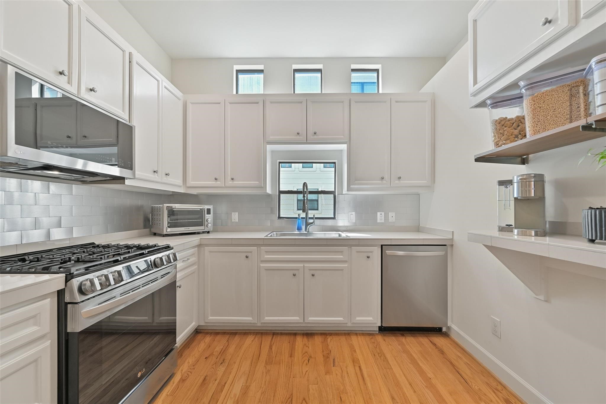 8715 Meadowcroft Drive, Unit 1002 Houston, TX 77063 - Photo 10 of 24 a kitchen with stainless steel appliances granite countertop a stove and a sink